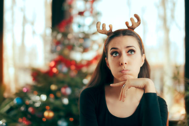 Sad Bored Woman Having No Fun At Christmas Dinner Party Funny girl wearing reindeer horns headband at Xmas Party office christmas party stock pictures, royalty-free photos & images