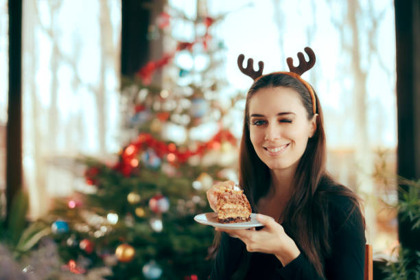 Happy Woman Eating Cake at Christmas Dinner Party Smiling girl eating dessert at Xmas festivity office christmas party stock pictures, royalty-free photos & images