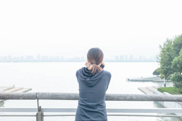 istock rear view of woman leaning on railing viewing scenery 866822776