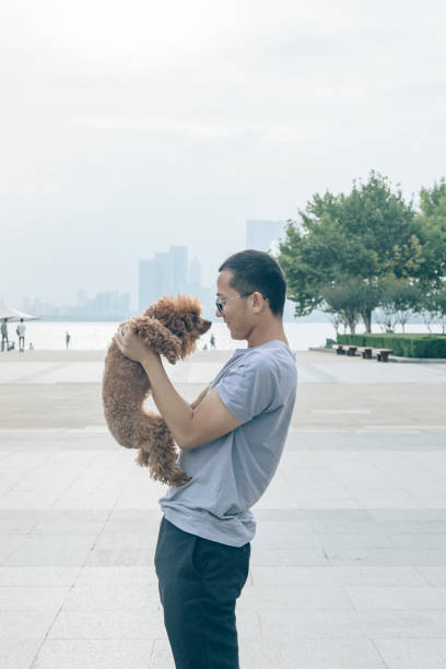 istock man playing with his puppy dog at urban waterfront 866822806
