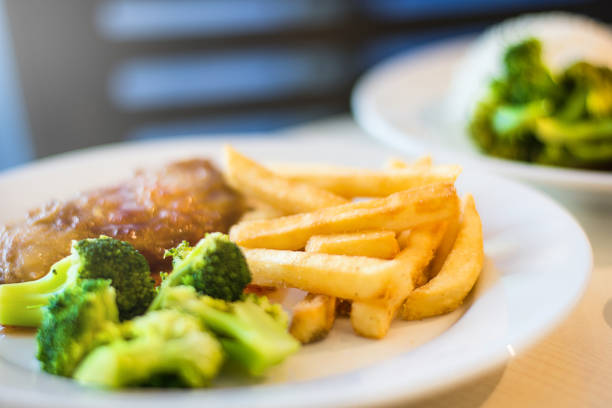 Grilled chicken with french fries and broccoli ,main focus on french fried.