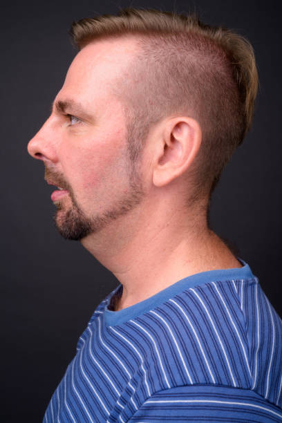 istock Blond goatee bearded man wearing blue striped shirt against gray background 866841144
