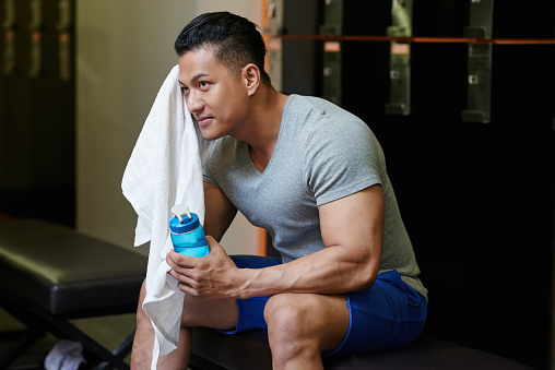 Mature man drinking water at the basketball court