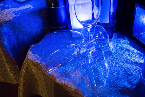 Empty wine glasses interlocking each other for decoration on the table under the blue light. Art of decoration