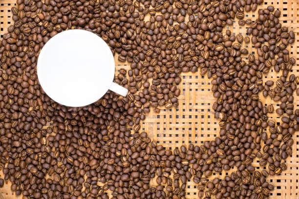 istock Flay lay style, Medium dark Roasted peaberry coffee beans with empty coffee cup on bamboo handcraft background. coffee lover concept with heart shape. 866871214