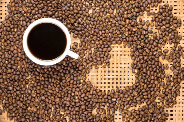istock Flay lay style, Medium dark Roasted peaberry coffee beans with black coffee filled in coffee mug on bamboo handcraft background. 866871222