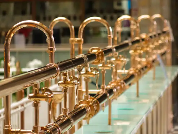 Brass water pipes in a spa, supplying different kinds of water for your health. Shallow DOF, focus on the front part.