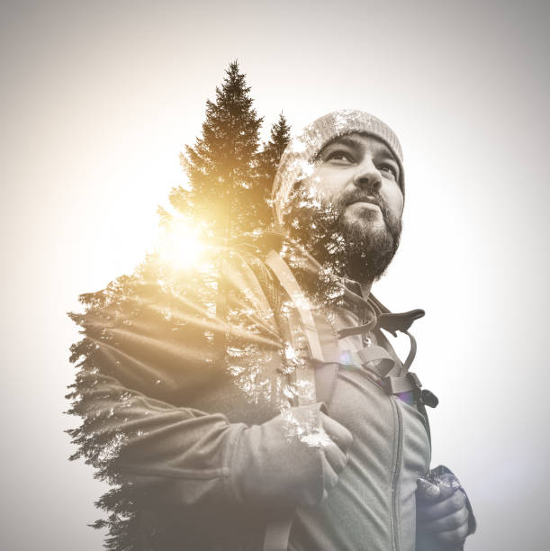 Close-up portrait of traveler walking alone in the mountains. Overcast sky over him.