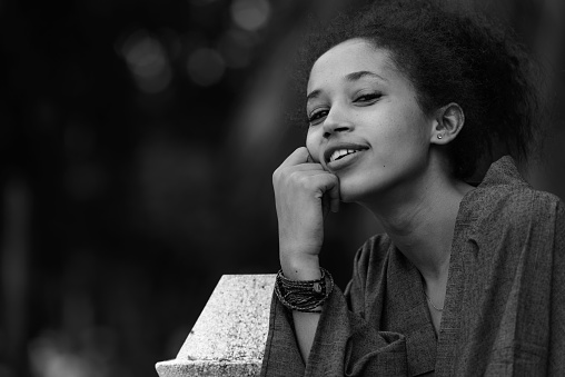 Portrait of young beautiful Ethiopian woman relaxing at the park in Bangkok Thailand