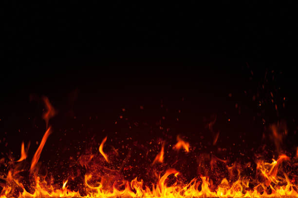 Real fire flames and sparks particles isolated on black stock photo