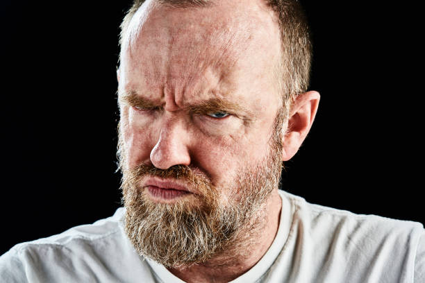 istock Mature bearded man grimaces, frowning angrily 866885688