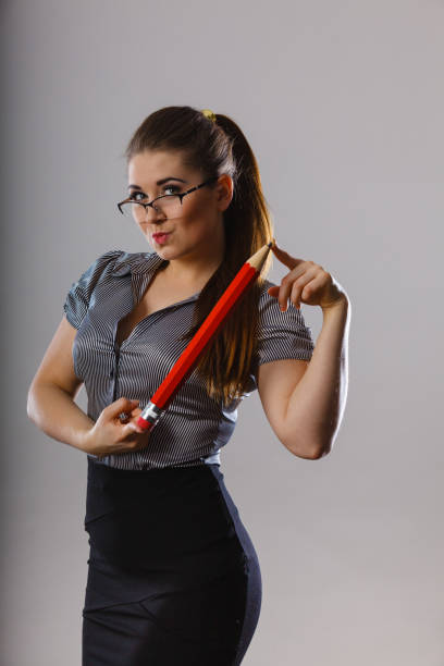 istock Teacher looking elegant woman holding big pencil 866887634