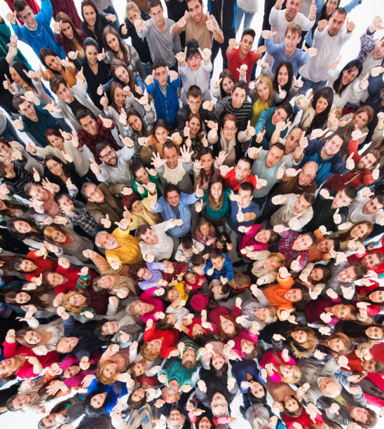 High angle view of crowd of people showing thumbs up. Above view of large group of happy people showing ok sign and looking at the camera. large group of people facing camera stock pictures, royalty-free photos & images