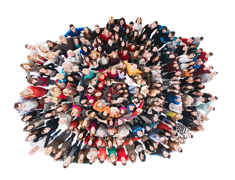 High angle view of large group of happy mixed-age people standing embraced in a circle and looking at the camera. Isolated on white.