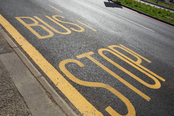 istock Bus stop sign with yellow paint on asphalt 866894070