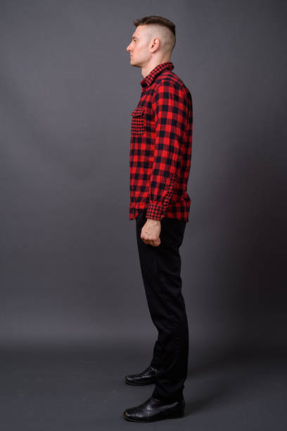 istock Young handsome man wearing red checked shirt against gray background 866894430