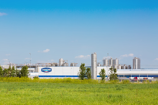 MOSCOW REGION, RUSSIA - AUGUST, 2017: Danone factory in Russia with green grass and blue sky.
