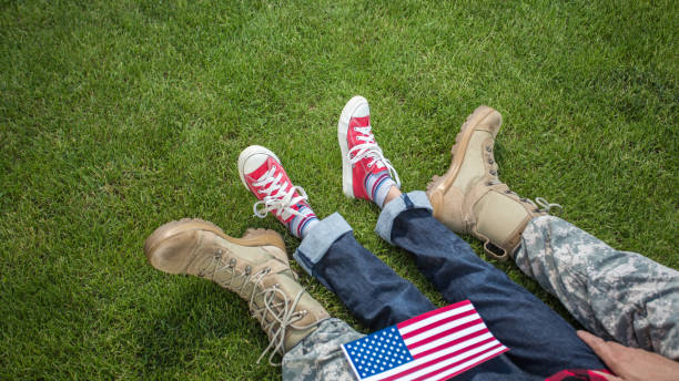 Happy reunion of soldier with family Happy reunion of soldier with family, father hugging son while sitting on grass military lifestyle stock pictures, royalty-free photos & images