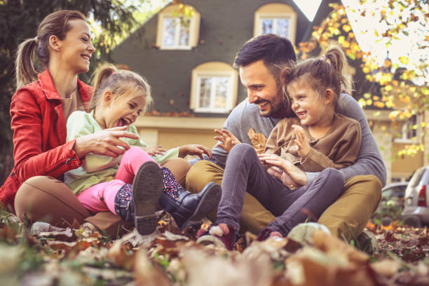 Mother and father playing with daughters outside.