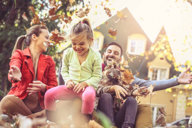 istock Happy family playing with leaves at backyard . 866897364