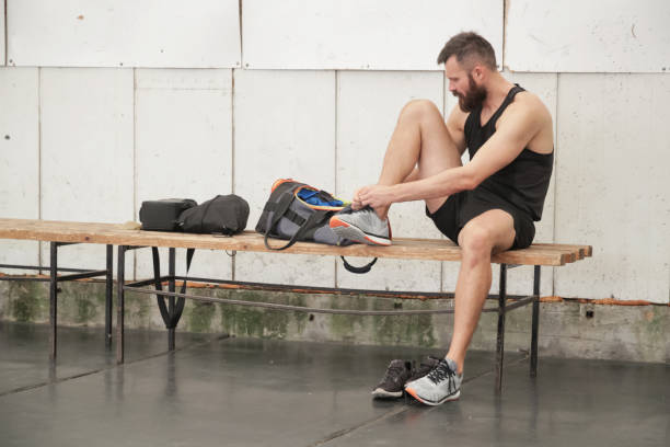 istock Man changing shoes in locker room 866898122