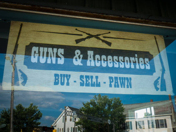 Guns & Accessories Waterville, Maine, USA - July 22, 2017: Guns and Accessories sign in the window of a local pawnshop, with a reflection of the town’s Main Street. Waterville is a city in Kennebec County of the U.S. state of Maine. gun laws stock pictures, royalty-free photos & images