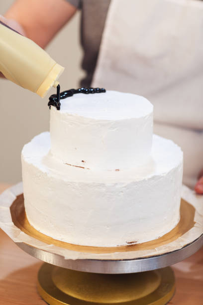istock Cream white cake poured with chocolate glaze, close-up, Vertical side view 866901534