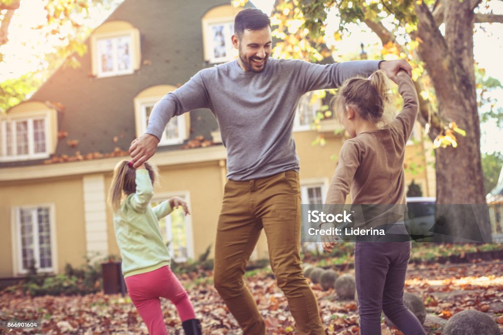Padre juega con hija en el patio trasero. - Foto de stock de Otoño libre de derechos