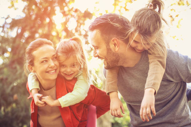 istock Parents walking with daughters carrying them on piggyback. 866901690