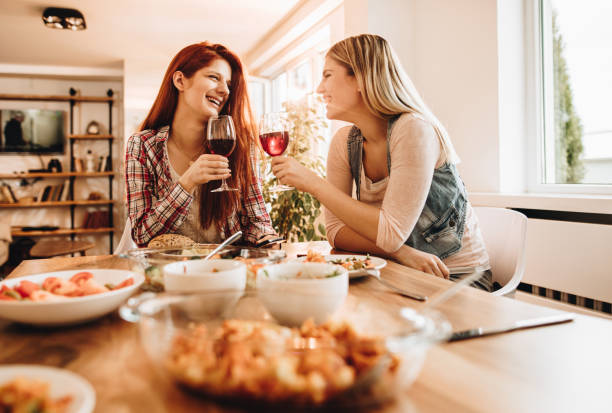 istock Young happy women talking and drinking wine during lunch. 866901694