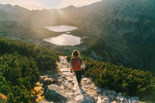 Woman walking   near the lake in Tatra  mountains Young Caucasian woman walking  near Morksie Oko lake in mountains in Poland eco tourism stock pictures, royalty-free photos & images