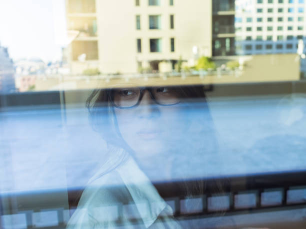 istock woman standing by window drinking coffee,seen through glass window 866904994