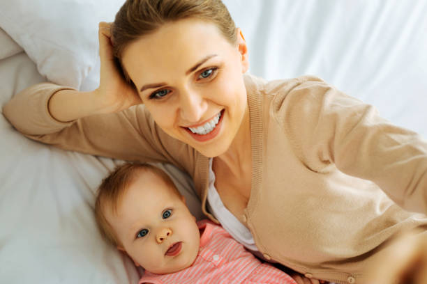 istock Positive mother making funny faces with her little baby 866905214