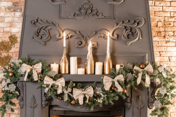 istock Christmas tree branch on fireplace and other holiday decorations in dark loft 866910416