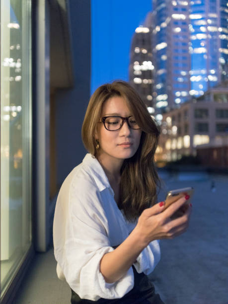 istock beautiful woman using smartphone in city at night 866912964