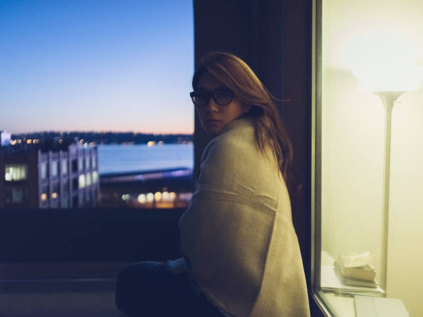 istock young woman wrapped in blanket sitting at night 866913524