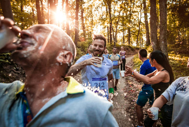 istock Athletic people running a marathon and refreshing themselves with water. 866913626