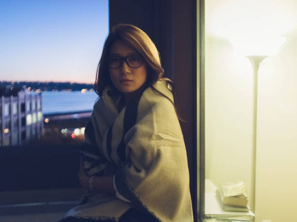 istock young woman wrapped in blanket sitting at night 866913704