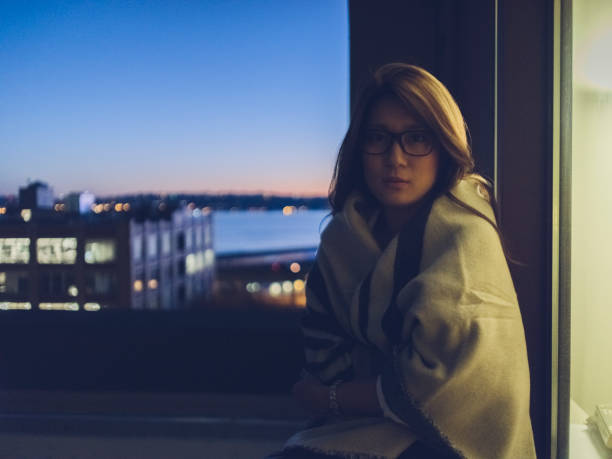 istock young woman wrapped in blanket sitting at night 866913740