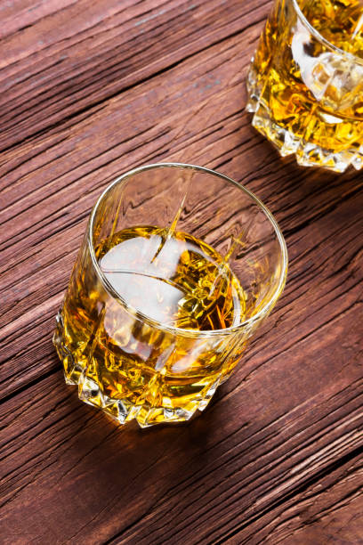 istock Whisky with ice in two glasses on a wooden background 866913990
