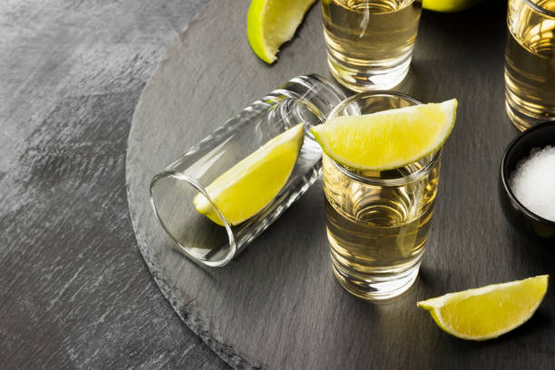 tequila con calce e sale su sfondo scuro. copiare lo spazio. sfondo alimentare - tequila shot tequila salt lemon foto e immagini stock