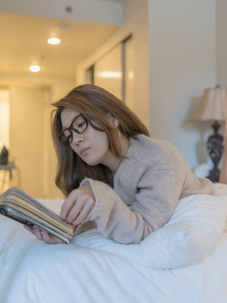 istock japanese woman lying on bed reading a book 866921506