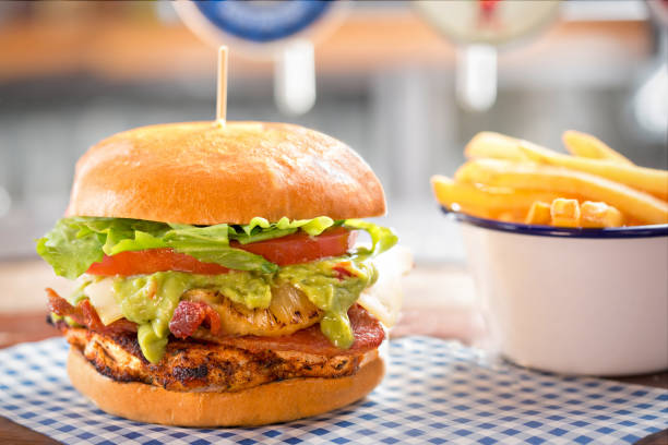 Grilled chicken burger with bacon, guacamole, pineapple, cheese, lettuce & mayo Grilled chicken burger with bacon, guacamole, pineapple, cheese, lettuce & mayo salad fruit lettuce spring stock pictures, royalty-free photos & images