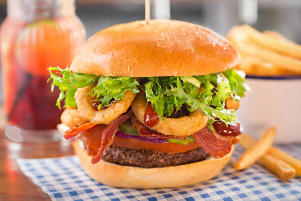 burger with beef, tomato, onion, pickles, bacon, onion rings, lettuce and barbecue sauce - salad food and drink food lettuce imagens e fotografias de stock