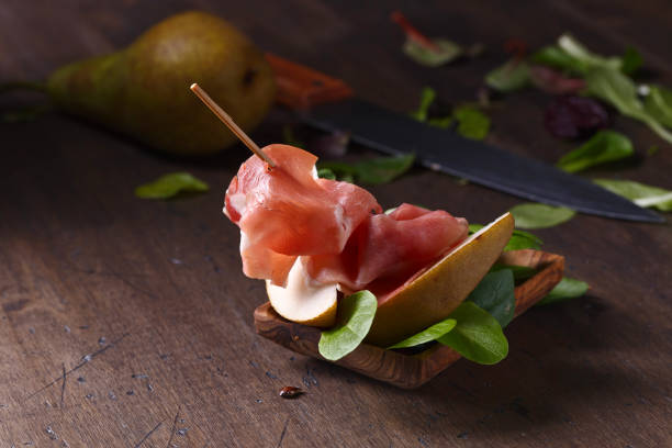 istock prosciutto with pear on a wooden table 866929022