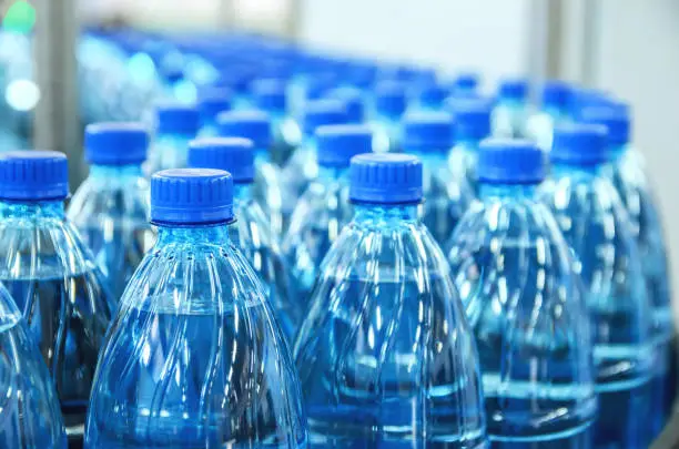 Photo of Closeup on mineral water bottles in raw and lines