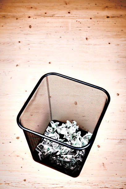 istock Wire mesh trash can with many discarded dollars 866935852