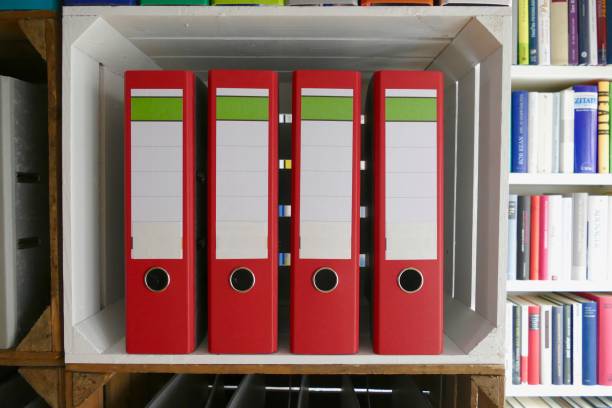 Red ring binders in front of book shelves