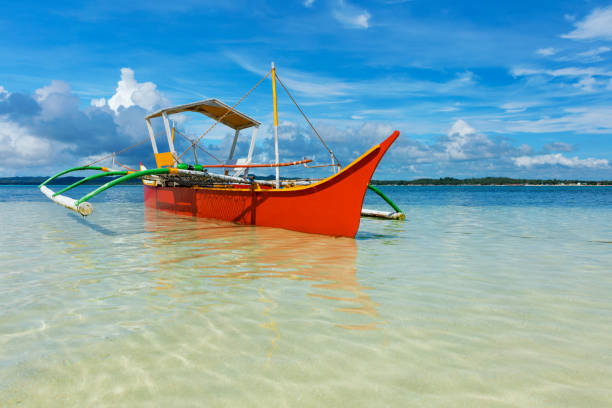 traditional fishing boat on pristine beach, philippines - nautical vessel philippines mindanao palawan imagens e fotografias de stock
