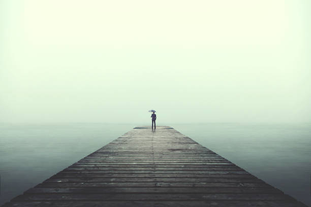 istock Sad business man with umbrella looking at the horizon 866944886
